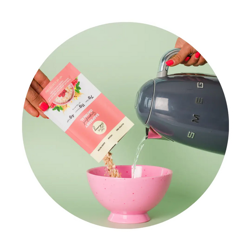 Instant oatmeal being made with a Smeg kettle in a pink bowl.