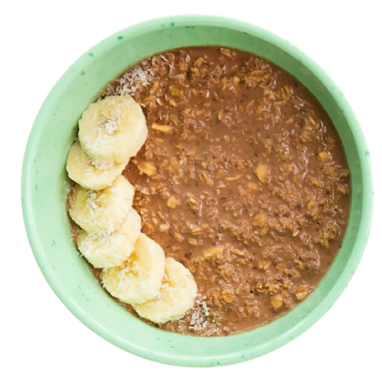 A bowl of chocolate protein overnight oatmeal with coconut and banana toppings.
